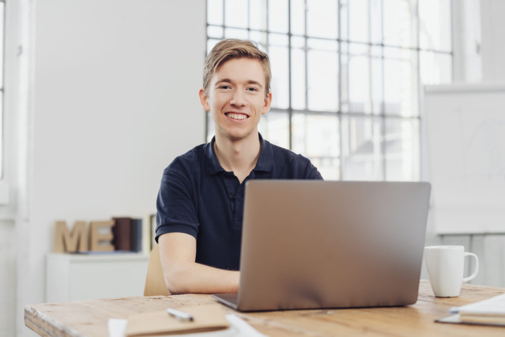 Young adult smiling as he completes training for his apprenticeship