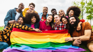 LGBTQ+ community posing with PRIDE flag