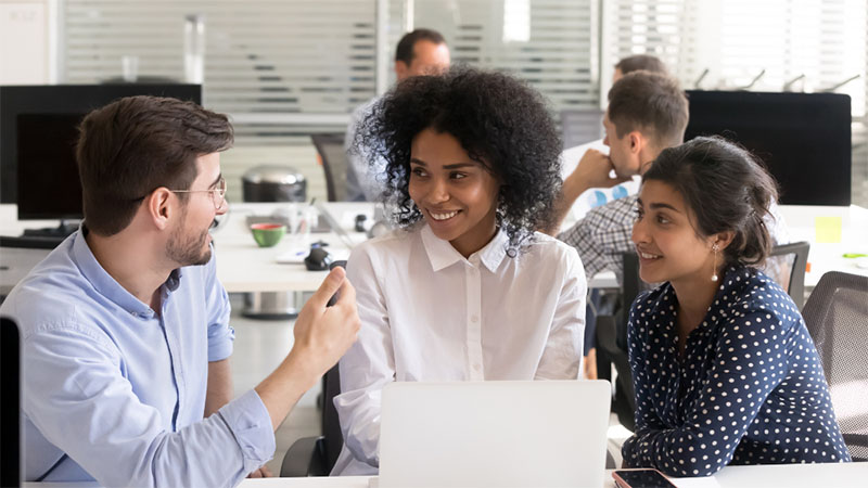 Three-young-professionals-sat-with-eachother-collaborating