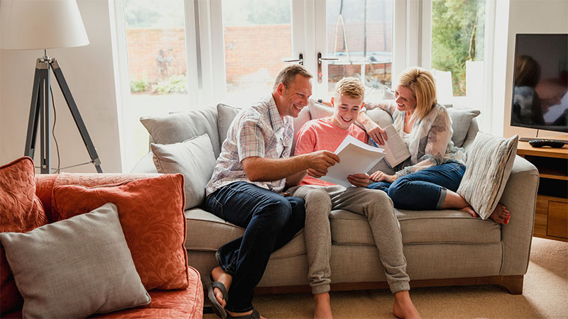 Student opening his results with his parents and smiling