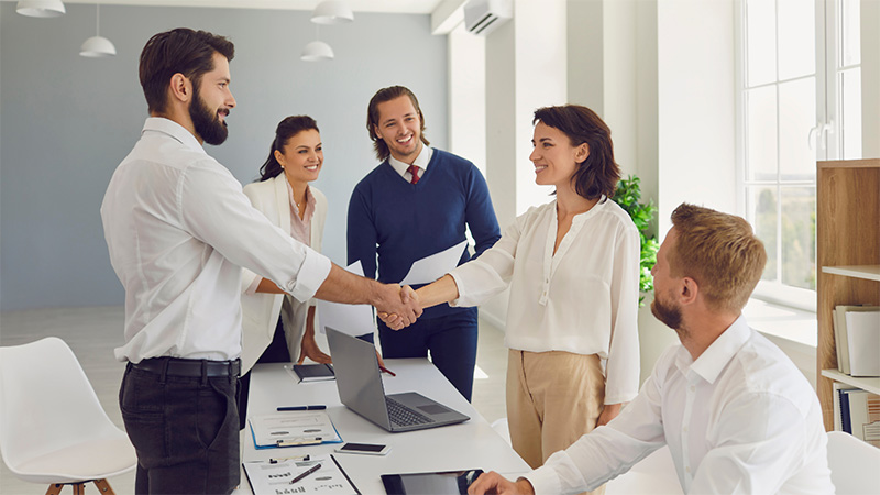 Two HR professionals shaking hands with each other